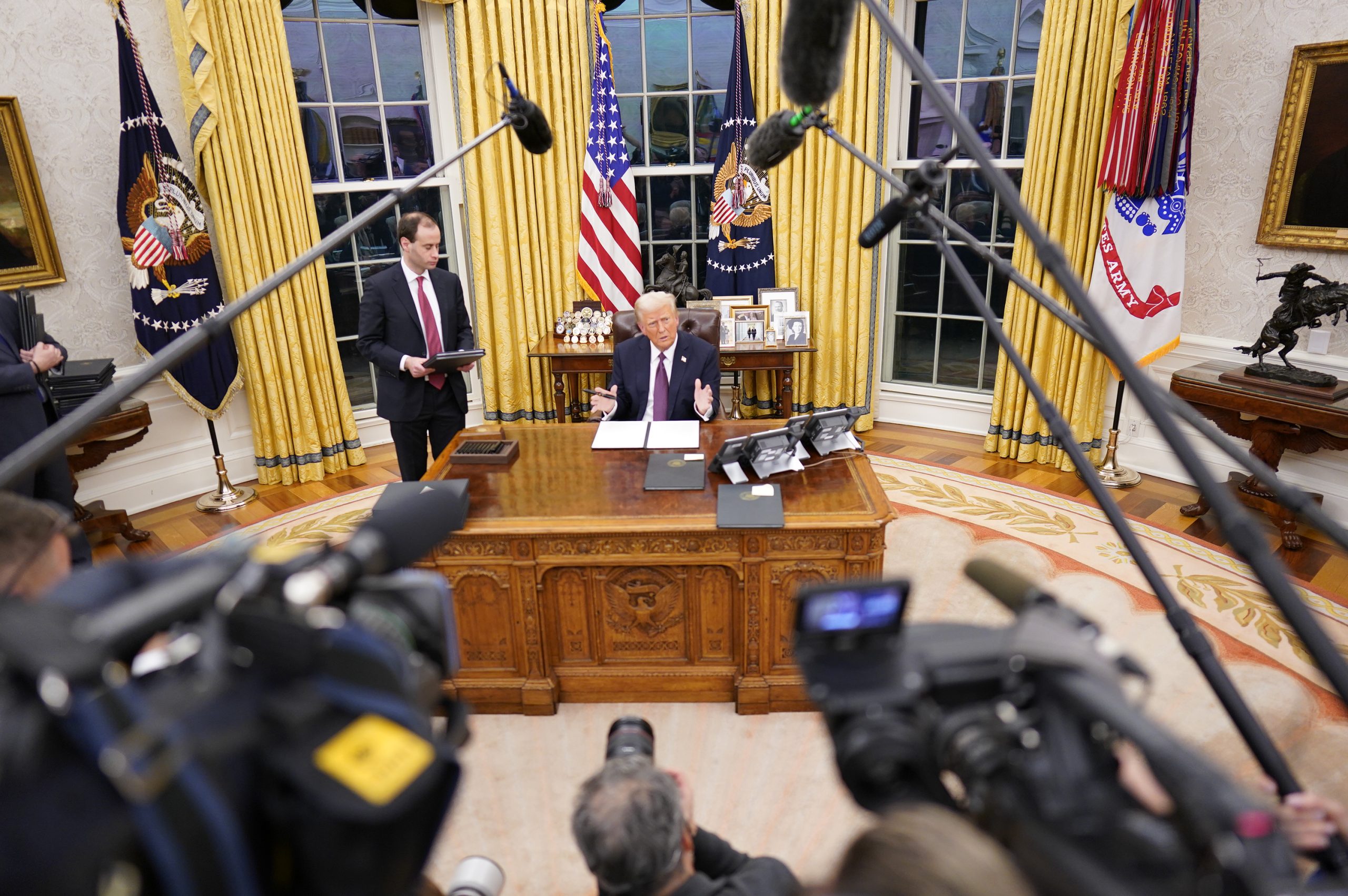 President Donald Trump signs executive orders in the Oval Office in Washington, DC. | Source: Getty Images