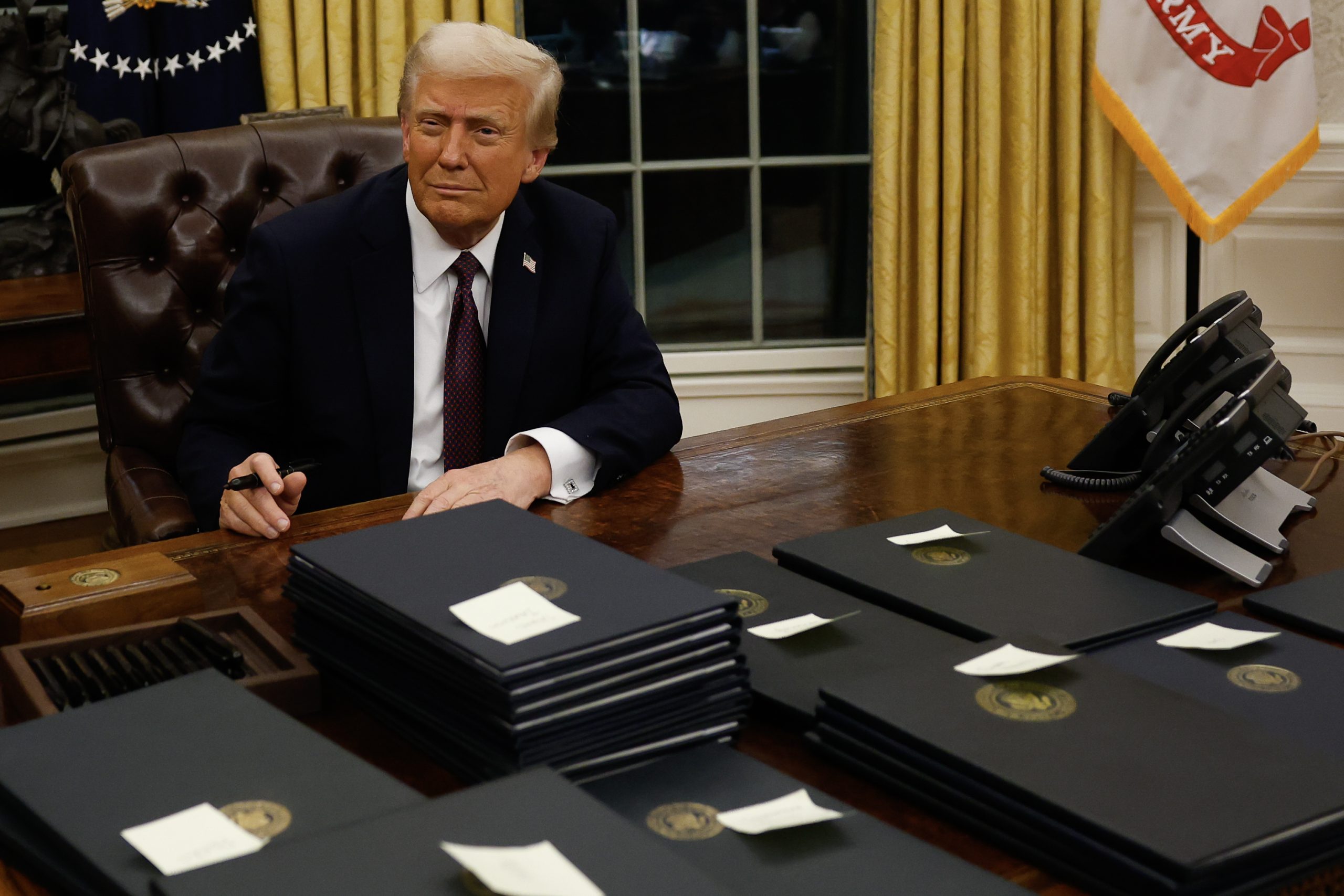 U.S. President Donald Trump signs executive orders in the Oval Office in Washington, DC., on January 20, 2025. | Source: Getty Images